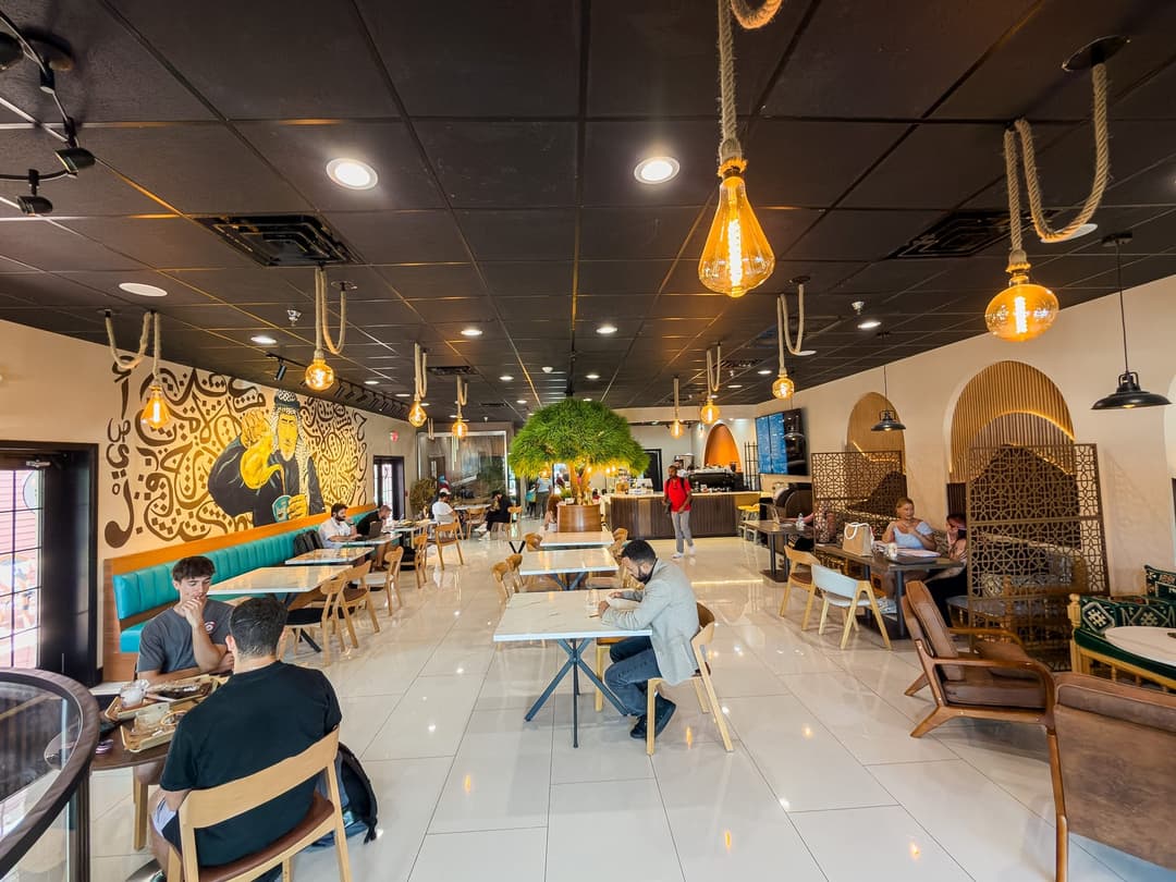 Inside Socotra Café in Temple Terrace: the Arabic calligraphy mural, rope pendant lights and marble tables